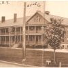 <p><strong>Colonial Revival</strong>: Early example of the style. Barracks (Building 63), built 1906, west facade with original wood porch, shown in view to northeast, ca. 1914.</p>